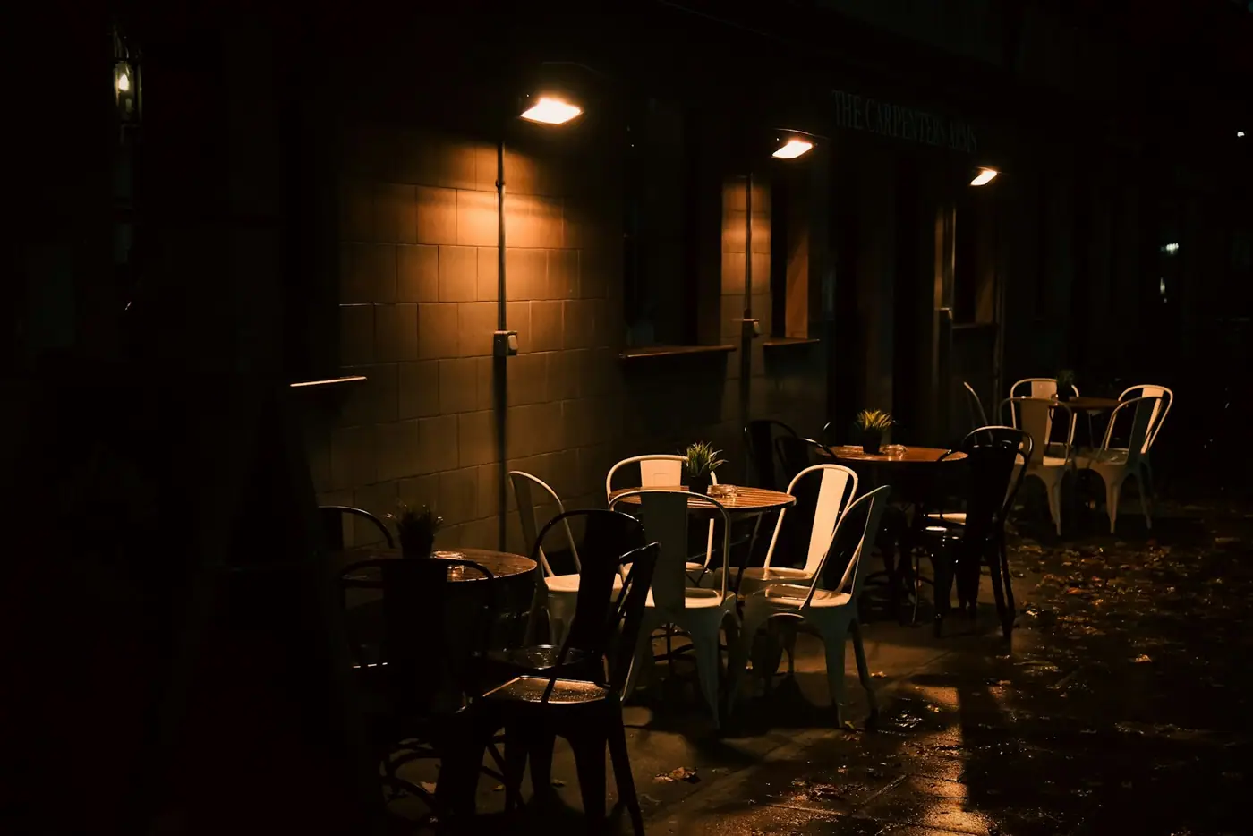 A row of tables in a moody restaurant at night